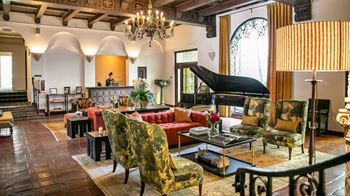 a living room filled with furniture and a large chandelier at Villa Carlotta – Furnished Apartments, Los Angeles, 90028